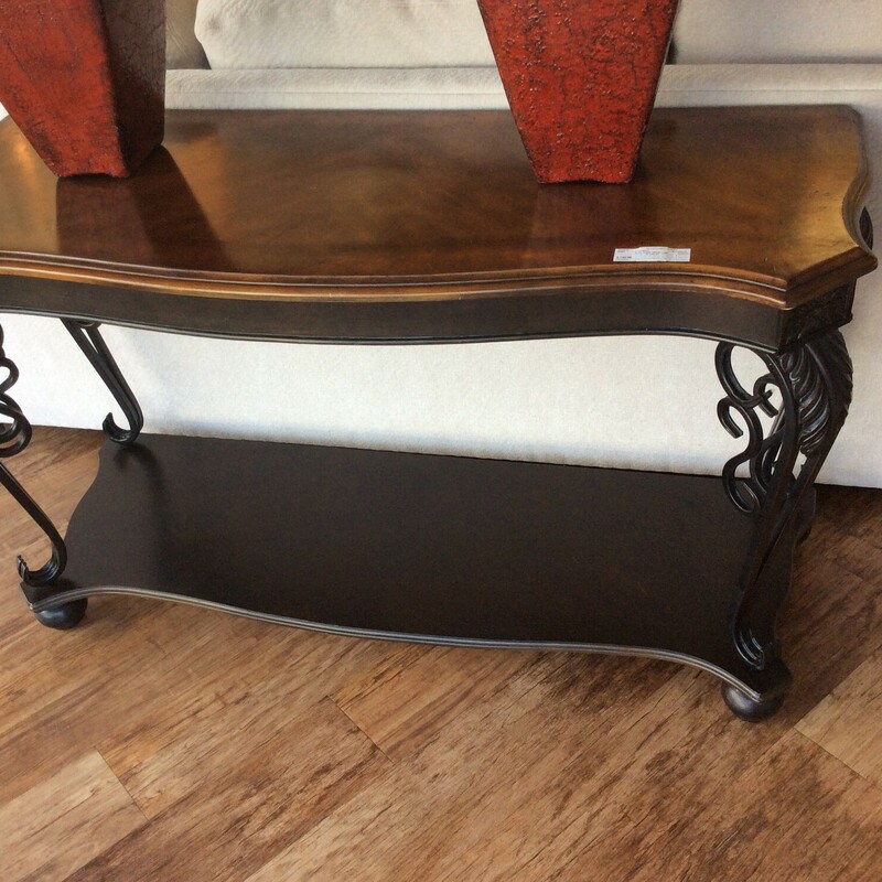 This traditional style Sofa Table has metal scroll legs and a bottom wood shelf.