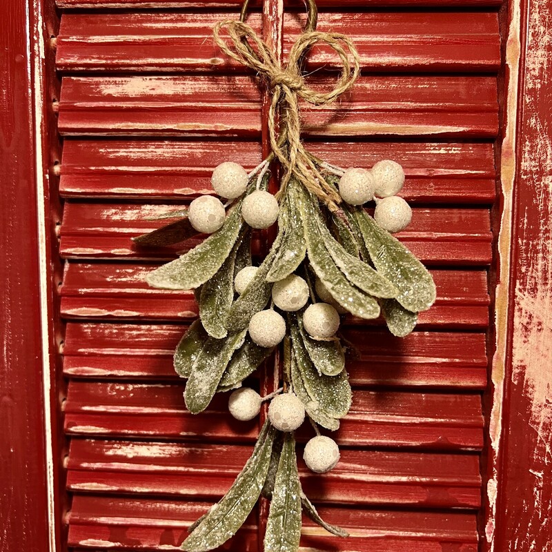 The Glittered Mistletoe Teardrop is made from light green mistletoe leaves accented by frosty white foam berries and finished with  sparkly silver glitter. It is tied with a decorative jute bow and comes with a loop hanger at the top for displaying in a basket; tucked in a floral arrangement or simply hanging in a doorway.  Measures 8 inches high.