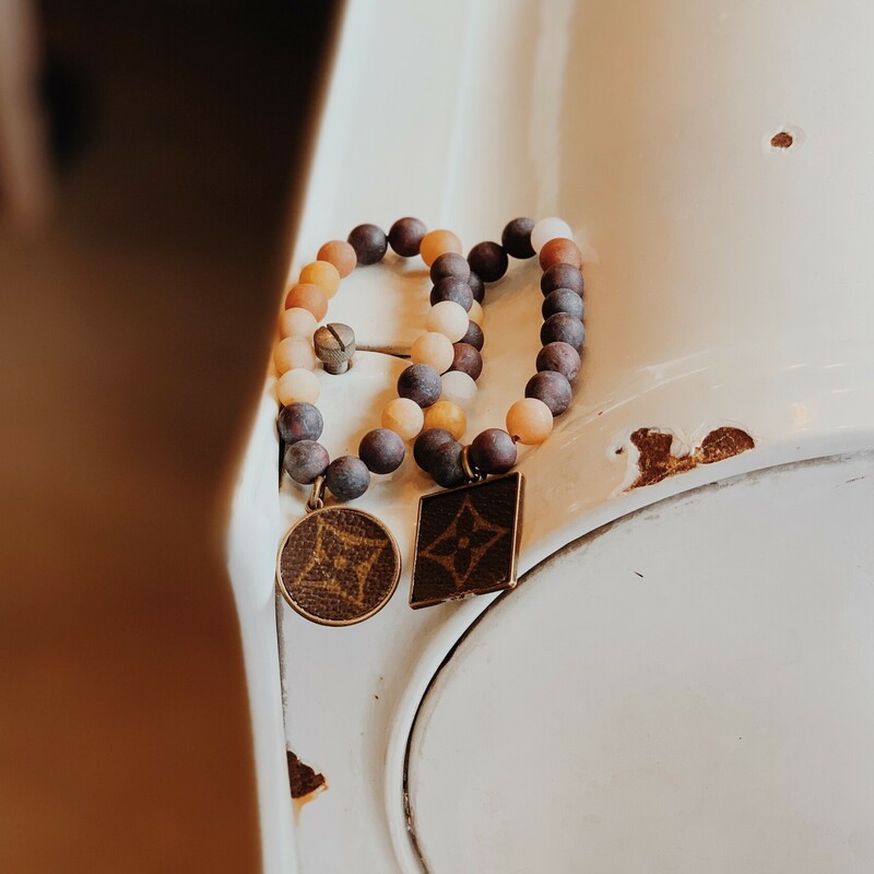 These gorgeous upcycled, handmade bracelets were made from an authentic Louis Vuitton bag!<br />
We currently have two different LV charm shapes to choose from.<br />
<br />
They are stretchy and adjustable in size.<br />
<br />
Resurrect Antiques is not affiliated with the LV company.<br />
The bag's date code is SP0927