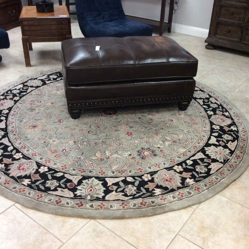 This is a sage green and black round Safavieh rug.