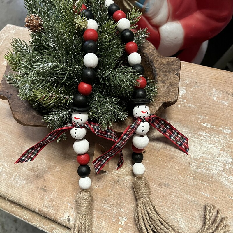 Do not miss out on getting yourself one of these adorable strands of Snowman Beads. This strand has two bead snowmen finished with top hats, plaid ribbon scarves and painted smiling faces. Each end is finished with a jute tassel and measures 34 inches long. These beads make a perfect gift or just for yourself drapped anywhere you want a cute finishing touch