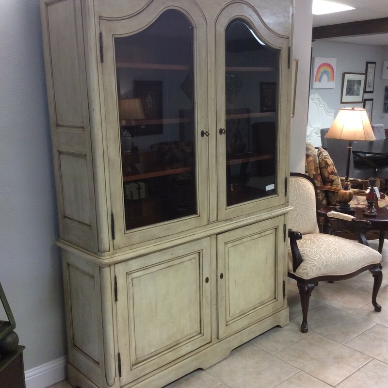 This Display Cabinet has a antiqued painted finish with scroll top doors and beveled glass.