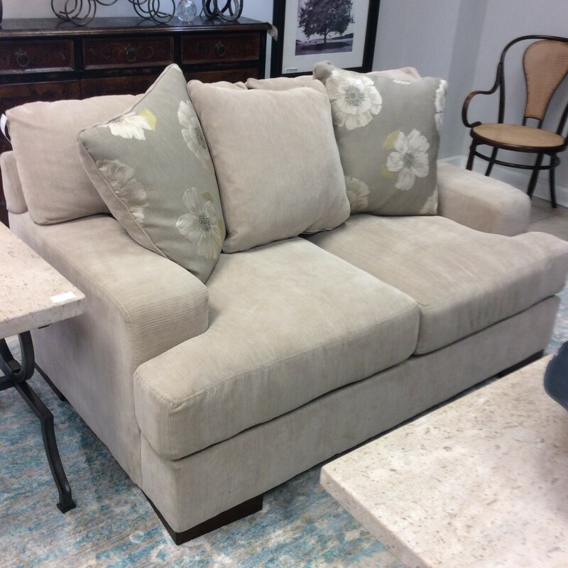 This versatile love seat is upholstered in a soft biege microfiber fabric.
