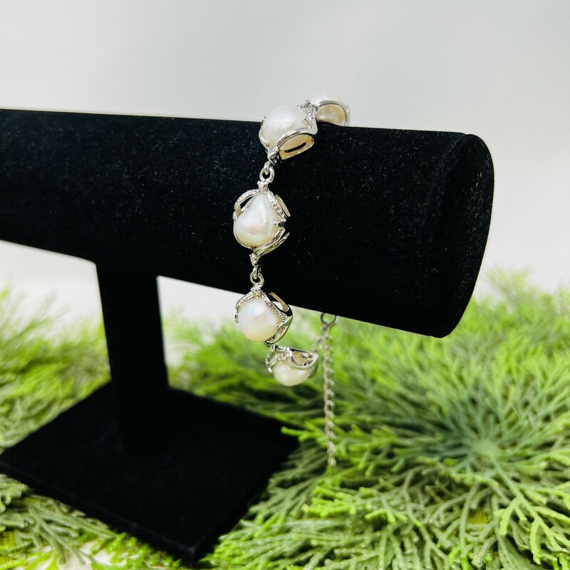 Fresh water pearl bracelet.

Silver tone statement bracelet with large white faux fresh water pearls.

The pearls are encased in silver textured place setting.

Has a lobster claw clasp.

10in long chain