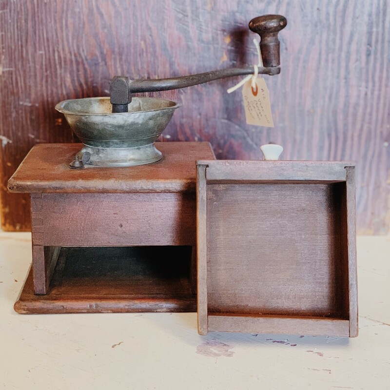 This antique coffee grinder is such a cool piece! It looks stunning on shelves, counters, and tables. This is a manual grinder and has a removable, wooden grounds catcher.

Measurements: 10 Inches (Height from bottom to handle) x 7.5 Inches x 7 Inches