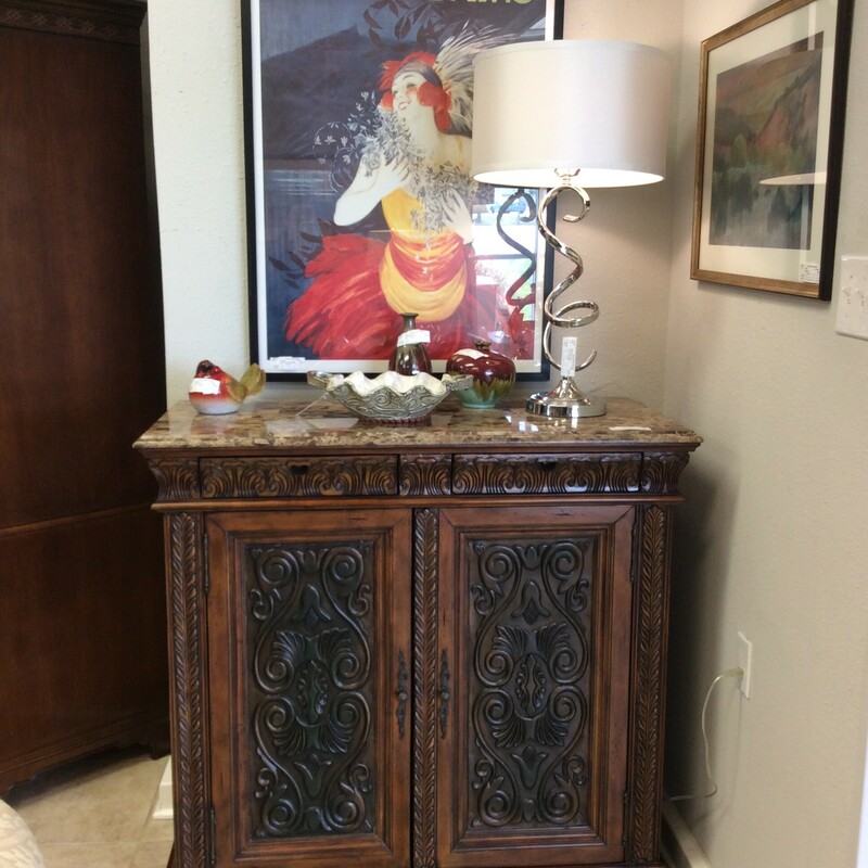 This beautiful console cabinet has embossed panel doors and a natural stone top.