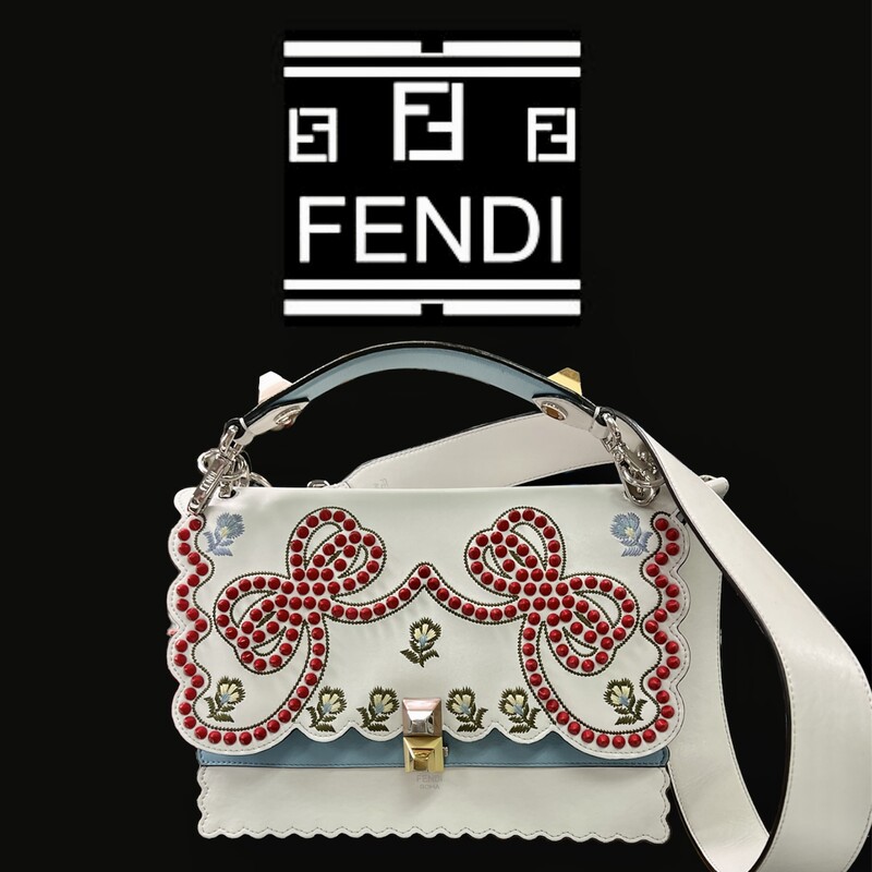 Fendi Kan I Handbag Embroidered Studded Leather Medium Handbag
This authentic Fendi Kan I Handbag Embroidered Studded Leather Medium is a uniquely designed bag perfect for the stylish fashionista. Crafted from white leather, this bag features contrasting studs in the characteristic bow design, embroidered flower details, leather top handle, detachable leather strap, double stud two-tone plexiglass twist-lock closure and silver and gold-tone hardware accents. Its twist-lock closure opens to an off white microfiber-lined interior divided into two compartments and with a slip pocket perfect for storing your bare essential. Its detachable strap allows this bag to be worn longer on the body for added versatility.
******Estimated Retail Price: $3,550*******
Condition: Very good. A-/B+ Wear consistent with age and use.  Slight curling on front, creasing on sides, minor wear underneath flap, and in interior. Minimal scratches on hardware.
Accessories: detachable strap and handle.
Measurements: Handle Drop 5\", Height 7.5\", Width 10\", Depth 5\", Strap Drop 18\"
Designer: Fendi
Model: Kan I Handbag Embroidered Studded Leather Medium
COMES WITH CERTIFICATE OF AUTHENTICITY