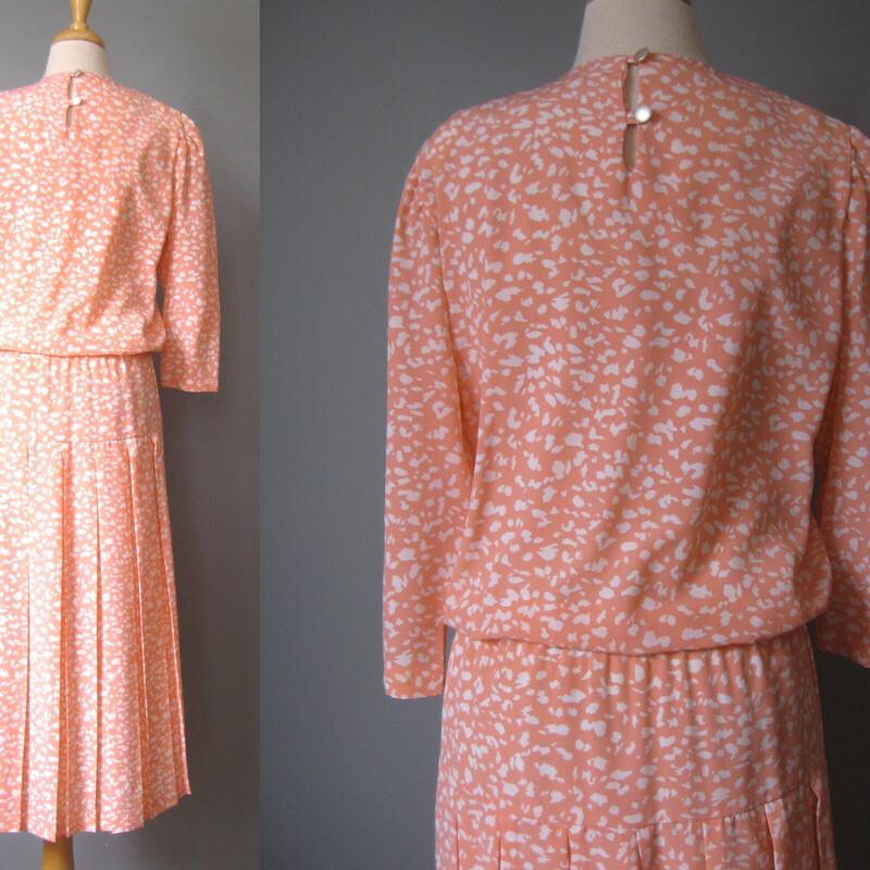 Here is a pretty peach and white secretary dress from the 1980s or late 1970s. Light and summery looking<br />
It doesn't have any brand or fabric identification tags. It's not silk or cotton, most likely polyester or acetate. Smooth flat woven fabric.<br />
<br />
High neck with pretty lace collar.<br />
two buttons and loops at the back of the neck<br />
The bodice blouses over the elastic waistline. It also has a seam across the hips.<br />
Unlined<br />
<br />
<br />
Flat measurements:<br />
Shoulder to shoulder: 14<br />
armpit to armpit: 19.5<br />
Waist: 15.75 unstretched<br />
Hip: 19<br />
Length: 49<br />
Underarm sleeve seam: 13<br />
perfect condition!<br />
<br />
Thanks for looking!<br />
#43719