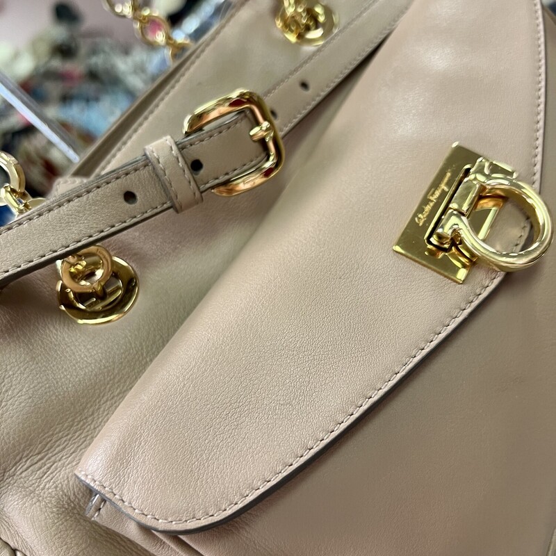 FERRAGAMO
Gancini Pocket Chain Bowler Bag Leather Medium

Designer: Salvatore Ferragamo
Dimensions: Height: 9.5 in (24.13 cm)Width: 13 in (33.02 cm)Depth: 5 in (12.7 cm)
Period: 21st Century
Material Notes:
Exterior Material: Leather Exterior Color: Beige
Interior Material: Fabric Interior Color: Beige
COMES WITH CERTIFICATE OF AUTHENTICITY

About the Designer:
Salvatore Ferragamo Clothing
A perfectionist who as a child crafted a pair of white shoes for his sister’s first holy communion because his parents couldn’t afford new footwear, Salvatore Ferragamo was ambitious from his earliest days. The young Italian shoemaker established in the years that followed what would one day become a fashion empire — the highly profitable multinational family-owned and -operated luxury brand today counts more than 600 stores in 96 countries around the world, and vintage Salvatore Ferragamo shoes, belts, handbags and other clothing and accessories are objects of desire for fashion lovers everywhere.

Salvatore Ferragamo sought an education in the art of shoemaking when he was eleven — he apprenticed with a local shoemaker and spent a short time in nearby Naples learning what he could at a shoe factory. He opened his first shop with a handful of workers the following year, and in 1914 — when he was still a teenager — Ferragamo emigrated to America, just as his siblings had before him, seeking new opportunities for work and to learn in the footwear trade.

After securing a job at the Plant Shoe Factory in Boston, Massachusetts, Ferragamo was uninspired by machine-made footwear. He moved across the country to Santa Barbara, California. Owing to a connection he made with a then-actor cousin, Ferragamo found work with the American Film Manufacturing Company. He made women’s shoes and provided durable cowboy boots for a film crew’s costuming department. Ferragamo’s reputation in the world of Hollywood cinema soon broadened, and he established a storefront in Mission Canyon where he made shoes by hand for the likes of actresses Gloria Swanson, Greta Garbo and Dolores del Río.

By the 1920s, film directors commissioned Ferragamo to produce shoes for a range of movies — the list of films eventually included The Ten Commandments, The Covered Wagon and The Thief of Baghdad. When he felt comfortable enough with the English language, Ferragamo also enrolled in anatomy courses at the University of Southern California in Los Angeles in order to better understand motion and the demands that we place on our footwear.

By the late 1920s, Ferragamo sought to expand production of his shoes and returned to Italy. He hired scores of apprentices to work in a factory in Florence, where Ferragamo carefully melded the principles of handcraftsmanship with all that he learned about America’s shoe factories. He filed patents — hundreds over the years — on the steel shank arch and many other unique aspects of his shoe design, and when economic and political influences during the 1930s forced Ferragamo to substitute pressed cork for steel to support the arch, the wedge heel was born. Other creative materials he integrated into his forward-looking creations were hemp, felt, nylon fishing line, fish skin and cellophane twisted with silk.

In the late 1940s, the brand’s first storefront opened in Manhattan, and today Salvatore Ferragamo is known worldwide and is synonymous with a wealth of iconic footwear such as Viva ballet flats, Vara Bow pumps, Gancini loafers and lots more. Ferragamo’s son, Ferruccio, was appointed CEO in 1984. Under his leadership, Ferruccio diversified and expanded the fashion business further, getting into sunglasses, fragrance, watches and made-to-measure men’s shoes. Ferruccio was succeeded by his brother, Leonardo Ferragamo, and British designer Maximilian Davis is now creative director of the brand.
