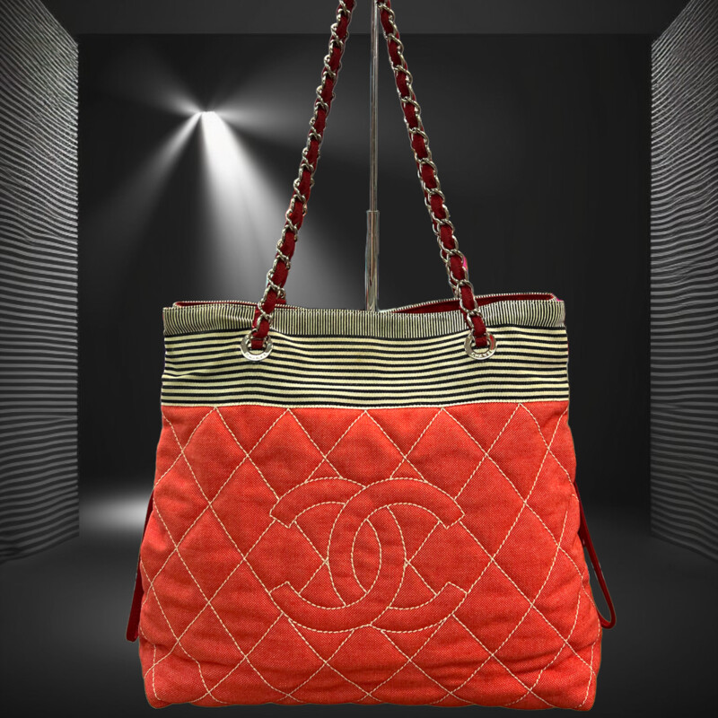 CHANEL

Chanel Red & Stripe Canvas Cruise Line Chain Shoulder Bag with silver-tone hardware, red canvas lining, interior slip and zip pockets, dual chain leather shoulder strap, and zipper closure at the top.
This bag does come with CERTIFICATE OF AUTHENTICITY!
Resale website Grailed has this bag in similar condition for $1895.00 and 1st Dibs ha this for sale for $1516.00

About the Designer
Chanel
In the years following the opening of her modest millinery shop, Gabrielle \"Coco\" Chanel became a pivotal designer of both fashionable casual wear and Paris haute couture as well as an icon and arbiter of 20th-century style with her bob haircut and pearls. Today vintage Chanel handbags, jackets and evening dresses are among the most sought-after clothing and accessories for fashion lovers all over the world.

The first Chanel shop was established in 1910 in Paris on rue Cambon by the young milliner Gabrielle Chanel (1883-1971), who had picked up the nickname \"Coco\" while working as a club singer. The boutique drew the attention of the Parisian fashion elite who popularized her wide-brimmed Chanel Modes hats. Soon she added a sportswear store in the Normandy resort town of Deauville, where Coco set the tone for her defining sense of style, traditionally masculine garments reimagined for feminine shapes, made from simple jersey fabric.

Effortless and elegant, Chanel's designs promoted comfort and grace in women’s wear that had been dominated in the previous century by complicated layers of fabric and cumbersome corsets. She followed this success with a couture house, opened in 1915 in Biarritz.

But Chanel was not born into a life of glamour. Following the death of her mother, her father left her in an orphanage where she lived until the age of 18. It was there that she learned to sew as well as appreciate the classic pairing of black and white as worn by the nuns. In 1926, she introduced her first little black dress, reclaiming a color that had once been reserved for mourning and working-class women. That same decade, she debuted her perfume, Chanel No. 5, as well as the Chanel suit with a fitted skirt, inspired by the boxy lines of men’s clothing and employing a sporty tweed.

Chanel closed her fashion operations during World War II, then returned to the industry in 1954 to design for the functional needs of modern women. Structure and wearability endured in all of Chanel’s clothing and accessories, like the quilted leather 2.55 handbag introduced in 1955 with its gold-chain shoulder strap that freed up a woman’s hands. Chanel's collarless jacket reacted against the constricting styles of Christian Dior's New Look, replacing them with a design that was timeless, an instant classic. The 1957 two-tone slingback pumps had a practical heel height while offering a bold statement in the black tip of the shoes.

After Coco Chanel died in 1971, the brand underwent several changes in leadership, including fashion designer Karl Lagerfeld, who took over as artistic director in 1983. Over the years, the company has continued to innovate, such as expanding into ready-to-wear fashion in 1978 and, in 2002, establishing a subsidiary company  \"Paraffection\" dedicated to preserving the heritage skills of fashion artisan workshops. The House of Chanel still operates its flagship on rue Cambon in Paris, where it all began.