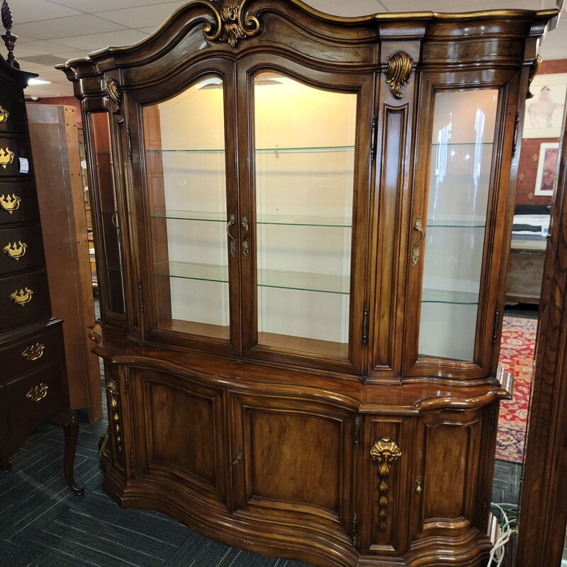 Impressive Designer French Regency China Closet in good condition with some minor finish wear.  Extremely high qaulity.  Comes in two pieces for easier transportation.  Has lighted interior; Curved Glass doorsnon sides and 4 doors in bottom for storage.  Does seem to be missing a wood shelf in bottom.  Also has 3 drawers for storage in bottom half.  Measures 81' wide; 83' tall; 21';deep.
