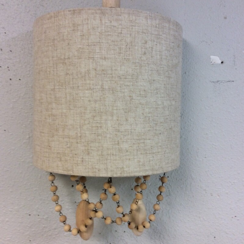This pair of wall sconces have  fabric covered shades and strands of hanging wooden beads.