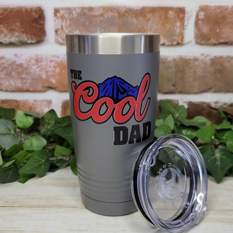 Dad will love his new custom tumbler. Our tumblers are UV Printed with the image shown of the Cool Dad with blue mountains.

Our Tumblers are powder coated and stainless steel; double wall vacuum insulated. Keep your drinks ice cold longer and it is great for hot beverages. The clear lid even allows for use of straws!- Double wall 18/8 stainless steel construction

- Features copper insulation that keeps drinks HOT for 8 hours and COLD for 16 hours
- Tapered design that easily fits in cup holders
- Clear push-on lid
- No sweat Exterior
- Hand wash recommended

We UV Print the cups; so there is no worries of a vinyl decal peeling or coming off.
