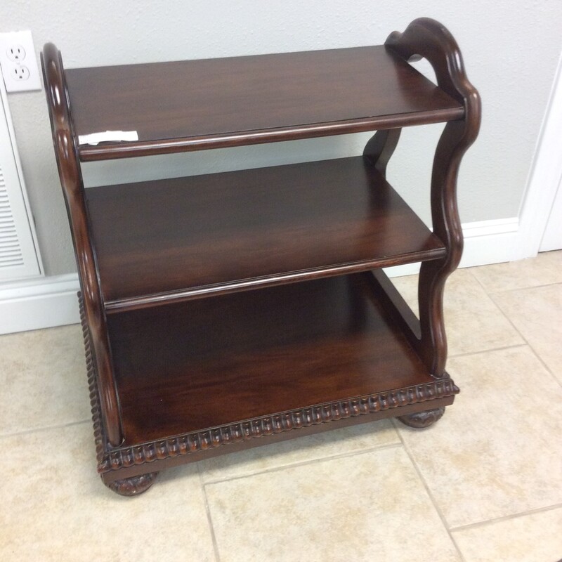 This unusual style 3  tiered shelf has bun feet, craved details, and a dark cherry finish.