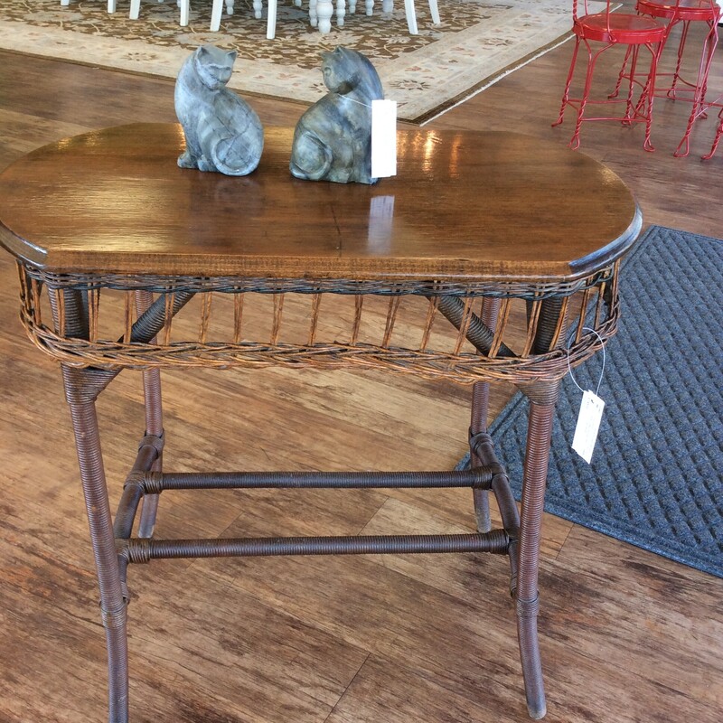This wicker side table has a wicker base with a stained wooden top.