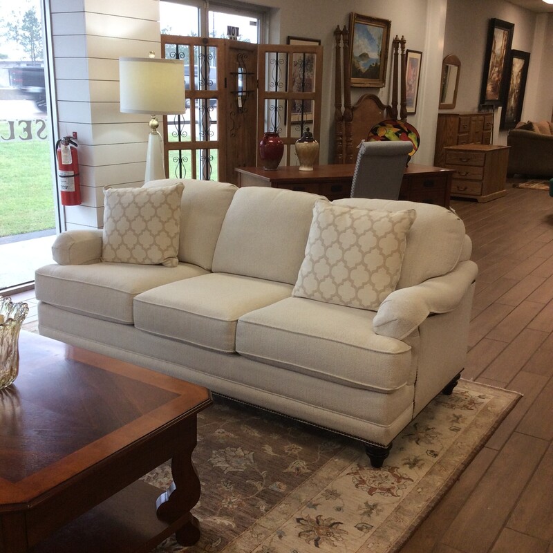 This sofa by Bassett Furniture is gorgeous! It's in perfect, pristeen condition besides being well-priced. It features, smart, cool, clean lines and is upholstered in a lovely off-white with a nailhead trim. Two accessory pillows are included.