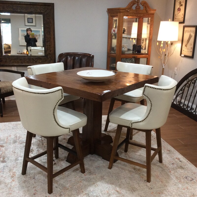 This is a great set! This is a counter-height table with 4 upholstered chairs. The table has a rough-hewn top with a solid, squared off pedestal base. The chairs are more contemporary in style, are upholstered in off-white and have a nailhead trim.