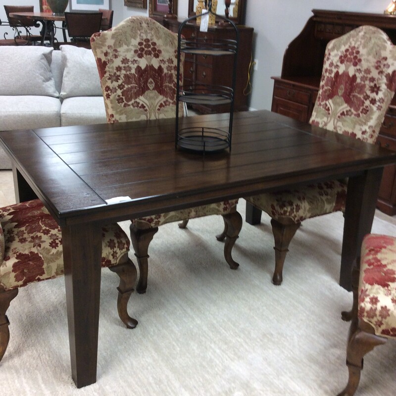 This rectangular dining room table is done in a dark pine finish.