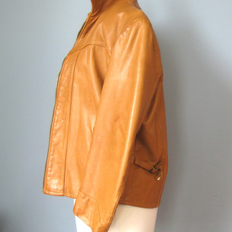 Vintage short leather jacket in rich golden tan brown<br />
fabulous buttery leather<br />
Fully lined<br />
Pockets<br />
interior wallet pocket<br />
<br />
Very cool, the sleeves are a little short so make sure that works for you.<br />
there strips of leather with buckles on each side so you can adjust the fit at the bottom.<br />
<br />
the label Rome declares the jacket to have been made in Peabody MA USA<br />
<br />
Interior measurements:<br />
shoulder to shoulder: 17<br />
armpit to armpit: 20<br />
width at hem: 17.25<br />
length: 22.25<br />
underarm sleeve seam: 14<br />
<br />
Excellent condition. No flaws.<br />
<br />
thanks for looking!<br />
#57384
