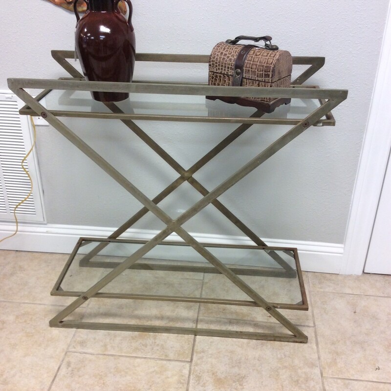 This stylish console table has a gold/silver washed metal frame with glass shelves.