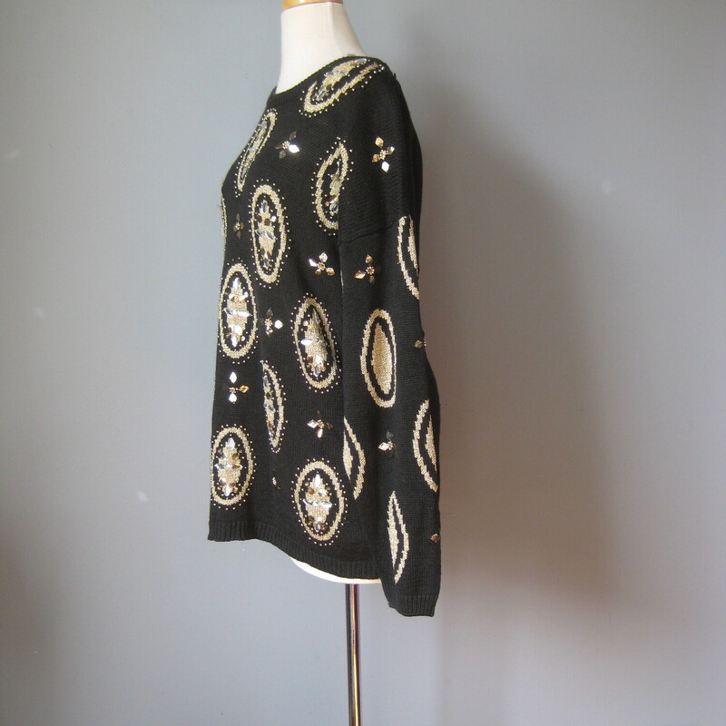 Gorgeous oversize vintage sweater in Black with a gold and clear plastic jeweled medallion pattern.<br />
55% Ramie and 45% cotton<br />
Marked size Medium but will fit a size large as well<br />
Flat Measurements:<br />
Shoulder to shoulder: 25.5<br />
Armpit to Armpit: 22.75<br />
Underarm sleeve seam length: 21<br />
Length from back neck to hem: 27.25<br />
width at hem unstretched: 22<br />
<br />
Excellent condition!<br />
#43192