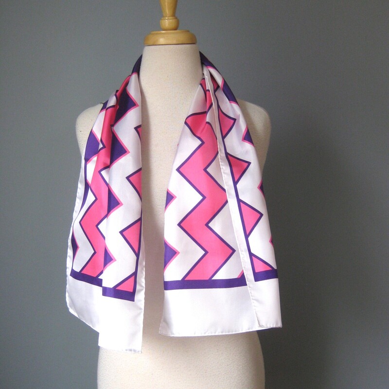 Oblong Scarf. Polyester.  This scarf has a high energy geometric chevron pattern in pink and purple on a white background.<br />
 44 long x 11 wide.<br />
<br />
no tags<br />
<br />
It is in excellent condition.<br />
<br />
Thank you for looking.<br />
#52395