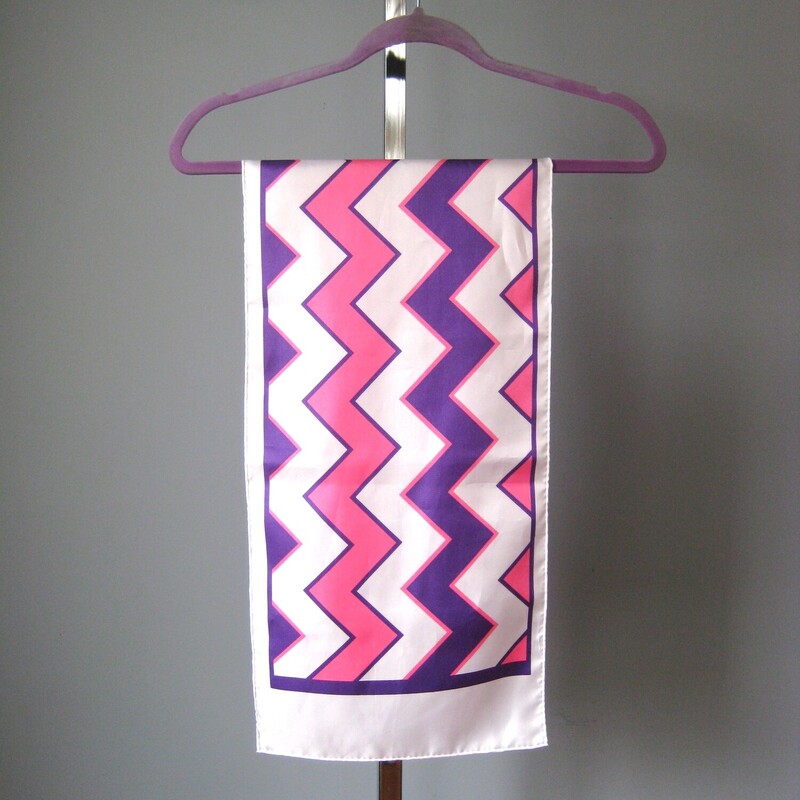 Oblong Scarf. Polyester.  This scarf has a high energy geometric chevron pattern in pink and purple on a white background.<br />
 44 long x 11 wide.<br />
<br />
no tags<br />
<br />
It is in excellent condition.<br />
<br />
Thank you for looking.<br />
#52395