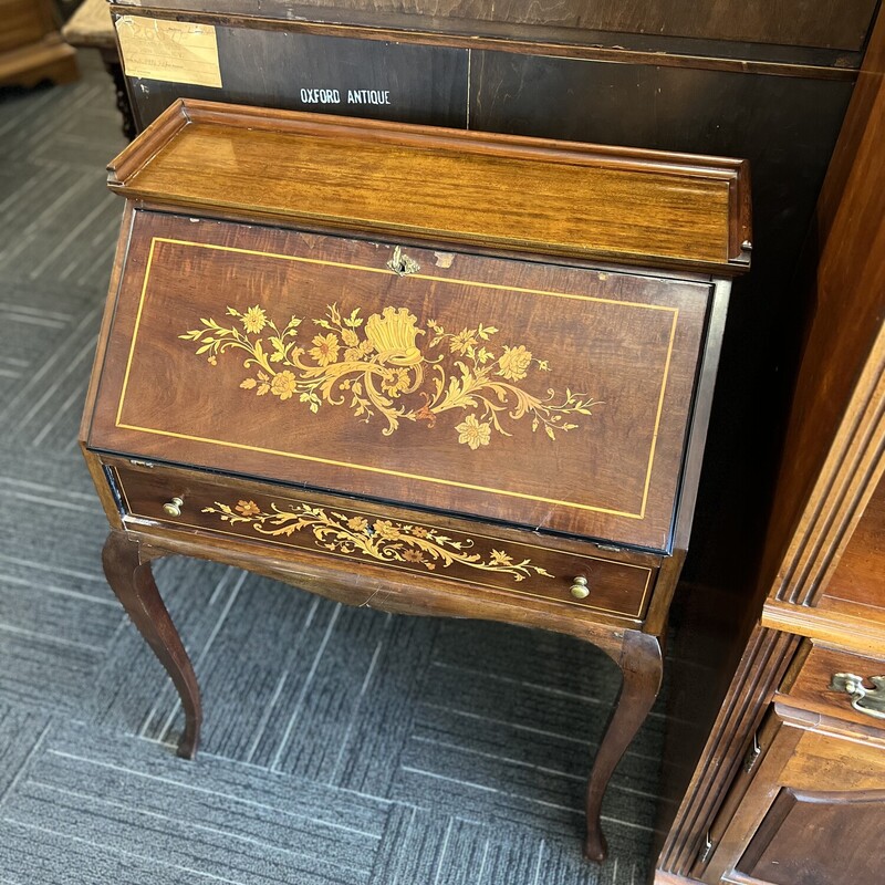 Rosewood drop front desk in fair condition; has veneer missing. Desk measures 28 inches wide; 39 inches tall; 16 inches deep. Drop down measures 11 inches long.