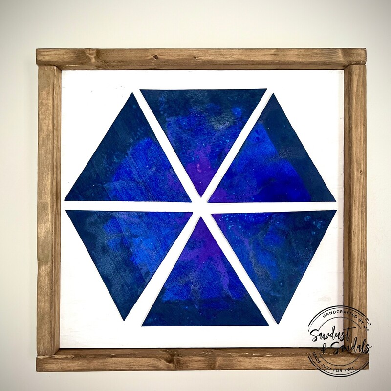 A glimpse of an ocean riptide on wooden triangular shapes arranged in a hexagonal pattern. Framed in aged neutral wood stain. This is Hand cut and Hand painted wood decor item.    A vibrant Ocean wave fluid art featuring shades of purples; blues and whites is captured on this unique design.
12.5â€x12.5â€   created by a local artist.