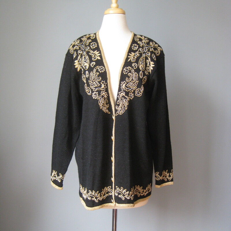 Gorgeous vintage sweater in black with a gold embroidered design with a few pearls
Acrylic nylon blend
Fancy black plastic buttons in gold tone filigree
Shoulder pads
Marked size L but may fit XL as well

Flat Measurements
Shoulder to shoulder: 19.5
Armpit to Armpit: 23
Underarm sleeve seam length: 19
Width at hem : 21.5
Length: 27

excellent condition.

Thanks for looking!
#43188