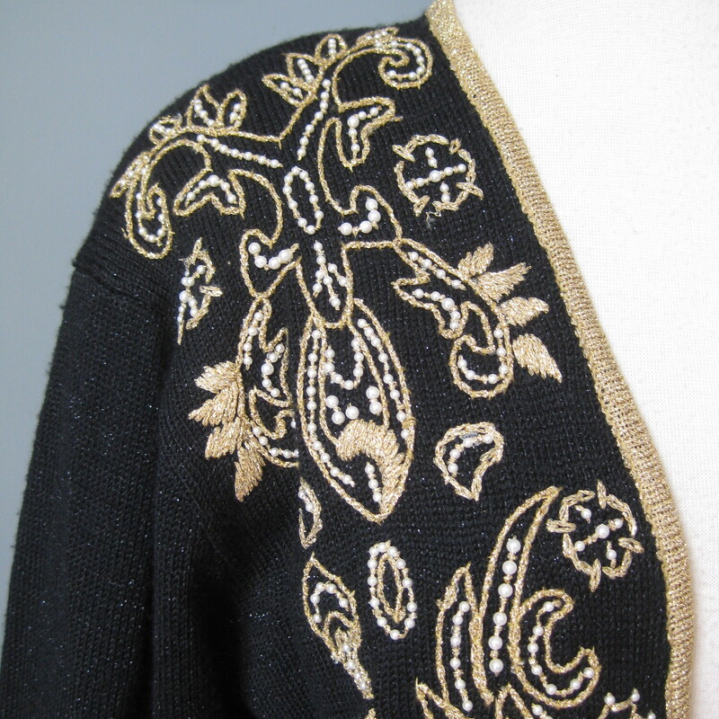 Gorgeous vintage sweater in black with a gold embroidered design with a few pearls<br />
Acrylic nylon blend<br />
Fancy black plastic buttons in gold tone filigree<br />
Shoulder pads<br />
Marked size L but may fit XL as well<br />
<br />
Flat Measurements<br />
Shoulder to shoulder: 19.5<br />
Armpit to Armpit: 23<br />
Underarm sleeve seam length: 19<br />
Width at hem : 21.5<br />
Length: 27<br />
<br />
excellent condition.<br />
<br />
Thanks for looking!<br />
#43188