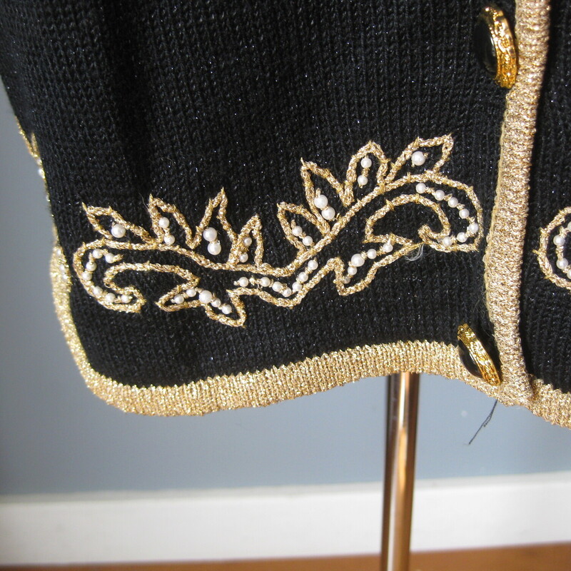 Gorgeous vintage sweater in black with a gold embroidered design with a few pearls<br />
Acrylic nylon blend<br />
Fancy black plastic buttons in gold tone filigree<br />
Shoulder pads<br />
Marked size L but may fit XL as well<br />
<br />
Flat Measurements<br />
Shoulder to shoulder: 19.5<br />
Armpit to Armpit: 23<br />
Underarm sleeve seam length: 19<br />
Width at hem : 21.5<br />
Length: 27<br />
<br />
excellent condition.<br />
<br />
Thanks for looking!<br />
#43188