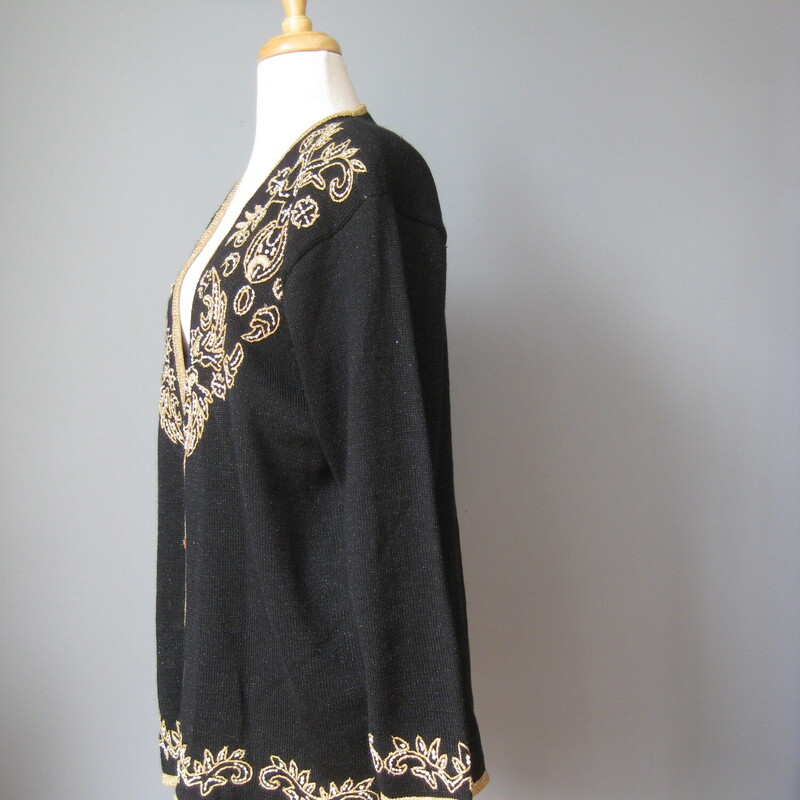 Gorgeous vintage sweater in black with a gold embroidered design with a few pearls
Acrylic nylon blend
Fancy black plastic buttons in gold tone filigree
Shoulder pads
Marked size L but may fit XL as well

Flat Measurements
Shoulder to shoulder: 19.5
Armpit to Armpit: 23
Underarm sleeve seam length: 19
Width at hem : 21.5
Length: 27

excellent condition.

Thanks for looking!
#43188