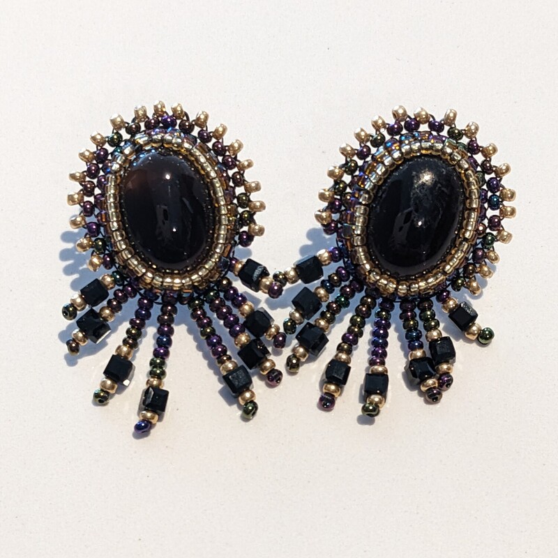 Grape Agate Star Earrings
Jama Watts
Jewelry (Bead Embroidery)
1.5 in long by 1 in wide
Dark brown agate cabochons surrounded by gold and irridescent purple seed beads with purple, gold and black fringe.  Backed with leather.  Stainless steel posts.