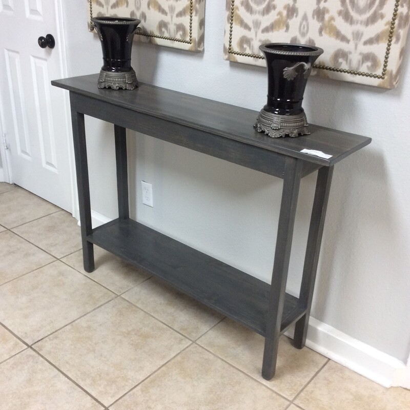 This sleek design entry table has a black wood base and a smoke gray stained top.