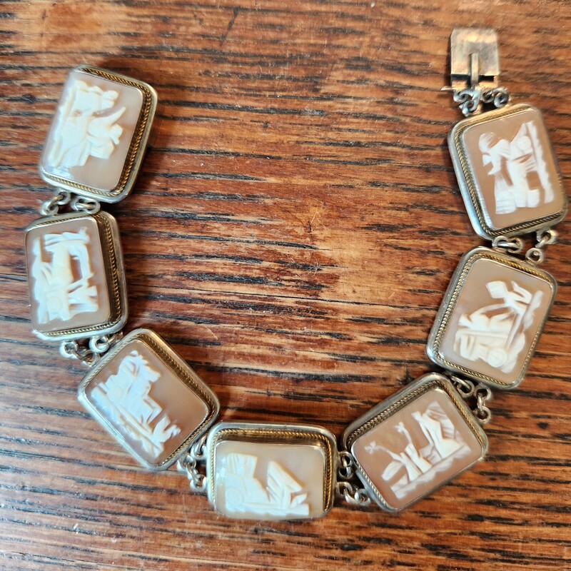 AMAZING CONDITION    .8 oz
Antique Edwardian SHELL CAMEO Bracelet and Sterling 925 depicting ROMAN life - chariot racers (circa 1901 - 1910)
Seven hand-carved shell cameos, each representing a day of the week, with a chariot driven by respective gods and goddesses, including: Mars, Mercury, Zeus, Aphrodite, Saturn, each being conveyed by different means - from left to right: A slave, two horses, two chickens, two birds on land, two birds in flight, one or two dragons and a team of four horses