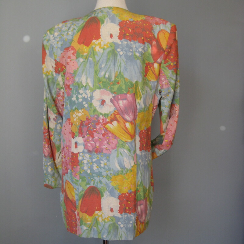 High quality collarless linen and viscose blend blazer in a beautiful floral print featuring large tulips and other spring flowers in rich but not loud oranges and blues<br />
Double breasted with white buttons<br />
Useful pockets<br />
Fully lined built in shoulder pads<br />
100% cotton<br />
Made in Germany<br />
<br />
Flat measurements:<br />
shoulder to shoulder: 17.75<br />
armpit to armpit: 22<br />
waist : 20  (not fitted here)<br />
hip: 22<br />
length: 32.75<br />
underarm sleeve seam: 16<br />
<br />
thanks for looking!<br />
#59079