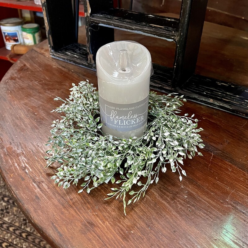 Little Luna Candle Ring has a grapevine base with stems of mini green leaves, accented with white, attached to the base. Ring has a 3 inch diameter and a 10 inch outside diameter. Use it around a candle or as a mini wreath accent on a wall or shelf groupings