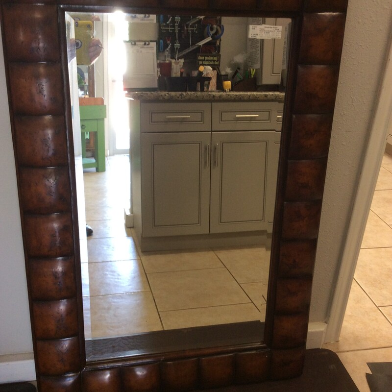 This handsome beveled glass mirror is surrounded by a solid wood frame.