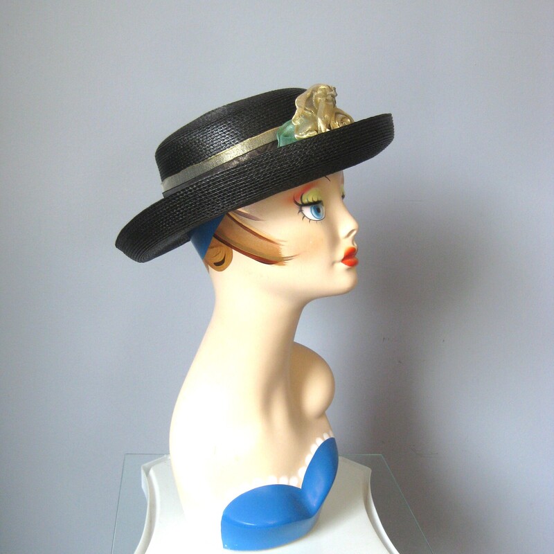 Tailored hat with a turned up brim and a flat top  in black straw with a gold ribbon around the crown finished with a pretty flower made of gold net.<br />
by Saratoga Track hats.<br />
inner hat band measures 21 around.<br />
Excellent condition!<br />
<br />
Thanks for looking!!!<br />
#3109<br />
<br />
For safety this hat, while very lightweight itself, will have to be shipped in a box, so the shipping on this item, which is built into the price is unfortunately a bit high.