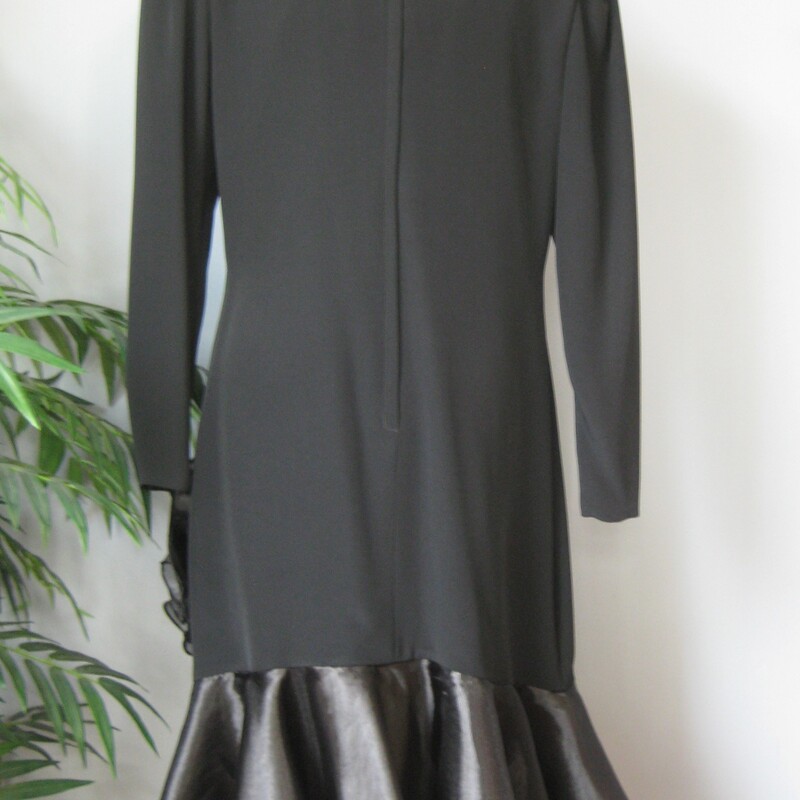 Vtg Hildegard Sausk, Black, Size: 16
This easy to wear black cocktail dress evokes the flapper style of the 1920s but it was made in the 1980s or ealry 90s.  It has bracelet length sleeves, a straight silhouette and a big flounce of lighter sheer organza at the hem, finished with a big flower.
Black crepe acetate with BIG shoulder pads.
Puffy sleeves.
The H shape silhouette is iconic of the era.

Marked size 16, but better for a modern size 12 or 14, depending on the bust.
Here are the flat measurements, please double where appropriate:
Shoulder to shoulder: 16.75
Armpit to Armpit: 21
Waist: 18
Hips: 22
Width at hem: 24
Length: 39.5
Underarm sleeve seam length: 16

Perfect condition!
Thanks for looking!
#3681
