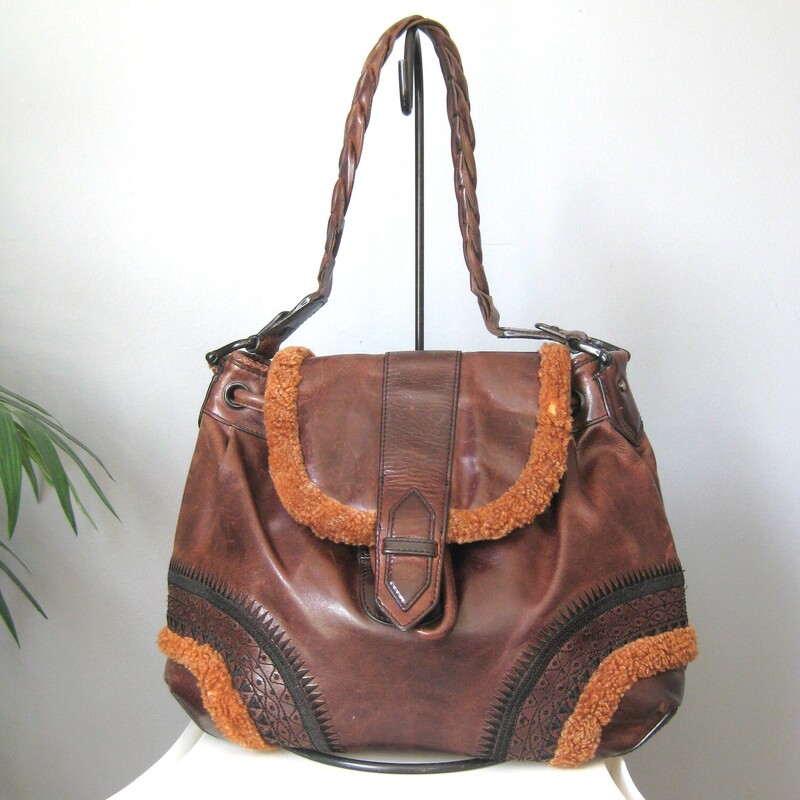 Cole Haan Embrd Lthr Fur, Brown, Size: None<br />
Vintage Cole Haan bag with bohemian flair.<br />
Large leather shoulder bag with rich brown and black leather and some orange-y shearling trim at the edges.<br />
Very cool<br />
Braided leather handle, tooled decoration<br />
It has a leather drawstrings areound the top edge.<br />
Fabric lining with two slip pockets and one zippered pocket.<br />
Magnetic snap closure.<br />
Good condition,  The shearling is worn off in a couple of spots, pls view all of my photos.<br />
<br />
Width: 14<br />
Height: 12.5<br />
Depth: 7.4<br />
<br />
Thanks for looking<br />
#3840