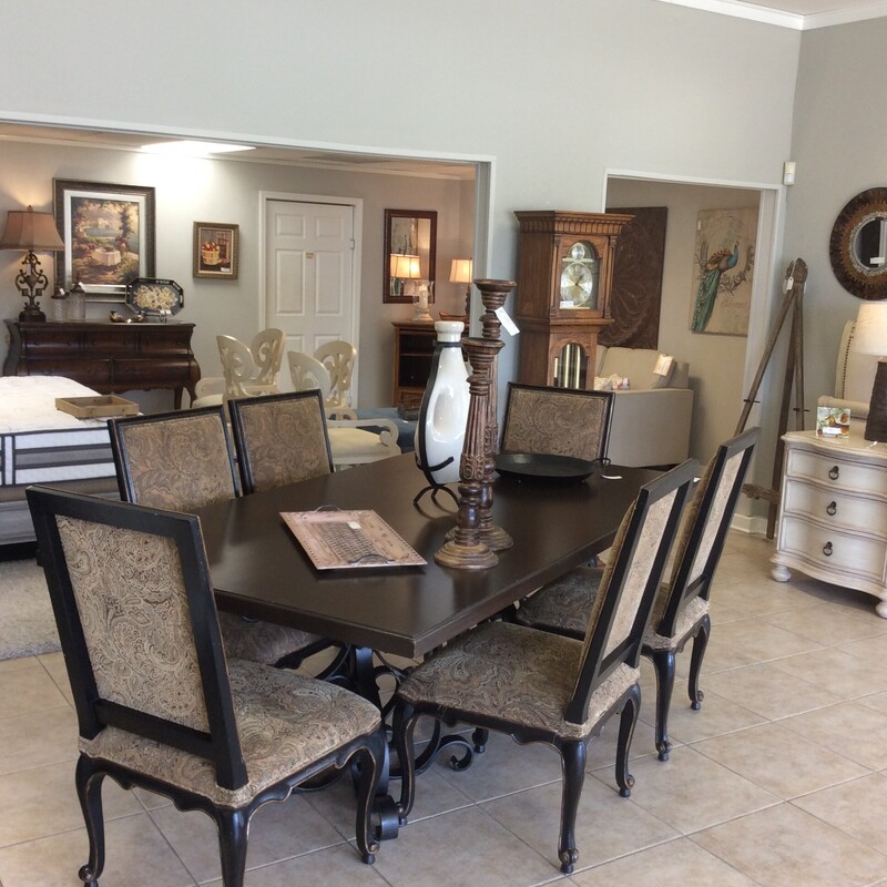 This is a beautiful diningroom table with 6 chairs. The double base is iron and the tabletop has a smooth, dark, wood finish. The 6 upholstered chairs have a painted and distressed wood  frame. The upholstery is a green, brown and gold paisley pattern.