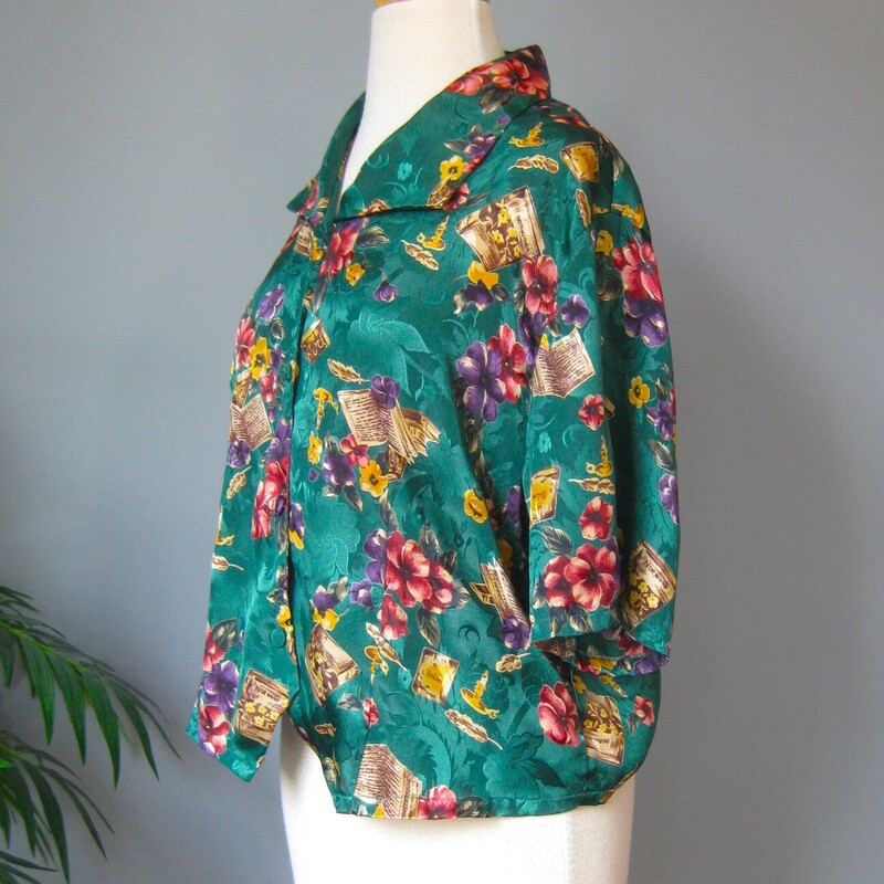 Vtg Silky Book Shirt, Green, Size: Medium
This is the PERFECT gift for your book nerd Friend !  Especially if they are enamoured of French Novelists.

It's a silk (but probably polyester) charmeuse jacquard in dark teal green, covered with purple and red flowers and sprinkled with candlesticks and books labled Balzac, Zola and Norwood ( apparently Norwood is a town in England to which the auther Zola fled after getting mixed up in the infamous Dreyfus case)
so fun and if you are or have a Lit grad student in your life how cute and unique would this be as a gift.

Excellent condition
Flat measurements, please double where approrpriate:
Shoulder to shoulder: 17
Armpit to Armpit: 22
Width at hem: 21.25 (it has a shaped hem so it will fit more smoothly if you want to tuck it in)
Length: 23.5

thank for looking!
#54290