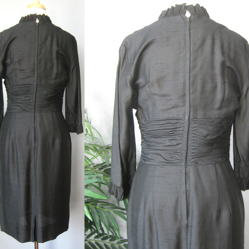 This is a simple little black dress from the 1950s. It features small tailored ruffles at the neckline and sleeve ends and a ruched middriff area.
It has no tags at all.
The fabric is lightweight and could be a silk or a linen silk blend, but I can't know for sure.
It has a center back metal zipper
unlined
3/4 sleeves

The dress is midnight black, I've pulled up the shadows in the photos a bit so you can see the details.

Excellent condition!

Here are the flat measurements, please double where appropriate:
Shoulder to shoulder: 16.5
Armpit to Armpit: 19
Waist: 14.5
Hips: 20
Length: 40.5
underarm sleeve seam: 11


Thank you for looking.
#59363