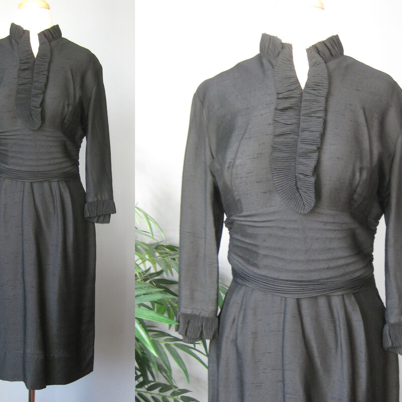 This is a simple little black dress from the 1950s. It features small tailored ruffles at the neckline and sleeve ends and a ruched middriff area.
It has no tags at all.
The fabric is lightweight and could be a silk or a linen silk blend, but I can't know for sure.
It has a center back metal zipper
unlined
3/4 sleeves

The dress is midnight black, I've pulled up the shadows in the photos a bit so you can see the details.

Excellent condition!

Here are the flat measurements, please double where appropriate:
Shoulder to shoulder: 16.5
Armpit to Armpit: 19
Waist: 14.5
Hips: 20
Length: 40.5
underarm sleeve seam: 11


Thank you for looking.
#59363