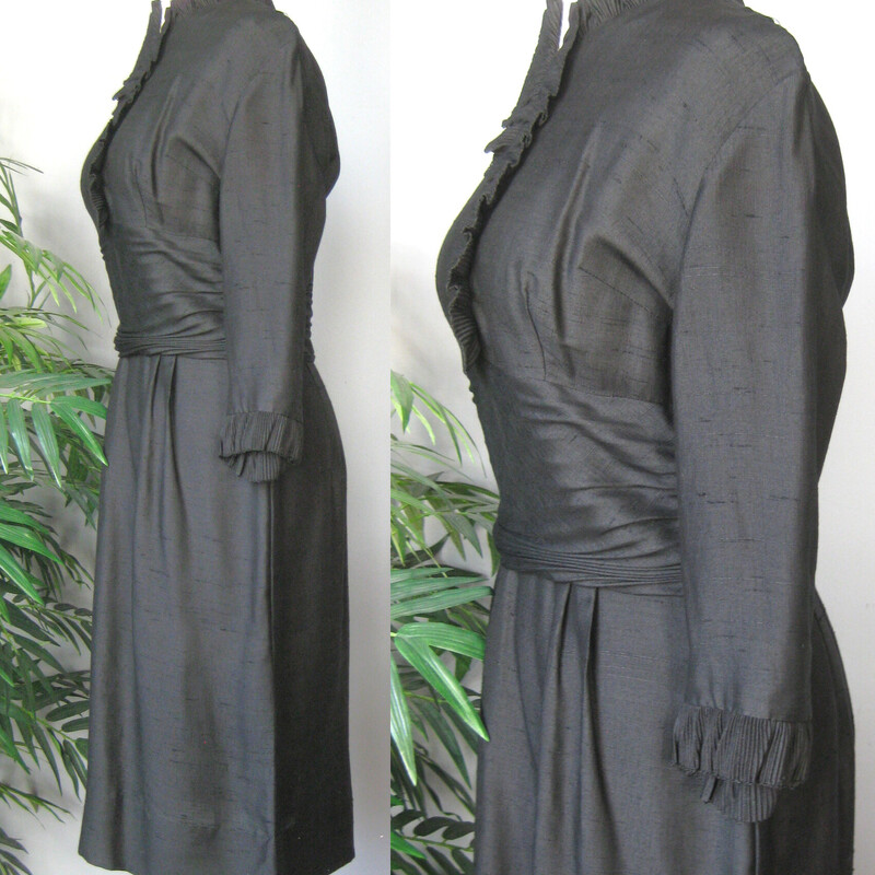 This is a simple little black dress from the 1950s. It features small tailored ruffles at the neckline and sleeve ends and a ruched middriff area.<br />
It has no tags at all.<br />
The fabric is lightweight and could be a silk or a linen silk blend, but I can't know for sure.<br />
It has a center back metal zipper<br />
unlined<br />
3/4 sleeves<br />
<br />
The dress is midnight black, I've pulled up the shadows in the photos a bit so you can see the details.<br />
<br />
Excellent condition!<br />
<br />
Here are the flat measurements, please double where appropriate:<br />
Shoulder to shoulder: 16.5<br />
Armpit to Armpit: 19<br />
Waist: 14.5<br />
Hips: 20<br />
Length: 40.5<br />
underarm sleeve seam: 11<br />
<br />
<br />
Thank you for looking.<br />
#59363