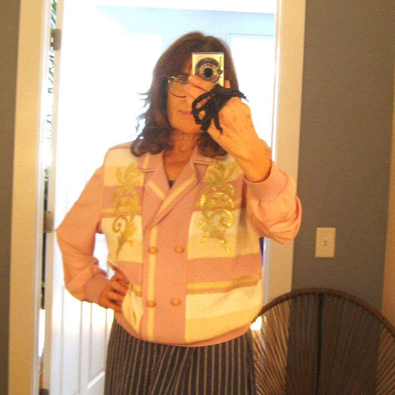 Vtg Philippe Shimmer, Pink, Size: L
Awesome quintessential 80s style knit pullover.
It's by Phillipe Marques
It's designed to look like a double breasted blazer or cardigan but it's a henley pullover.
Big shoulder pads

The body, cuffs and banded waistline are knit, probably acrylic but the garment doesn not have any fabric ID tags.
the sleeves and the back are thin woven polyester.
on the front are yellow, pink and white stripes topped with applied gold satin scrolls
The decorative buttons are pink plastic circles set in rope turned gold metal

CONDITION:
Alas it's not in perfect condition
There is a spot on the front near one of the buttons as shown
There are dark marks on the back of one of the sleeves (I tried to get this out without success)
There are some fabric imperfections on the back across the shoulders.
All these are pictured.
Item is priced accordingly, I would wear this and I don't believe any gal who buys and wear vintage or thrifted items would be unhappy with it.

It fits likee a large or even extra large but has no size tag.
Here are the flat measurements, please double where appropriate:

Shoulder to shoulder: 16 3/4
armpit to armpit: 22 3/4
underarm sleeve seam length: 17 1/2
Length: 25 1/2
width at hem: 17 stretches comfortably to 22, this will sit at the natural waist creating a slight blouson effect

Thanks for looking!
#54367