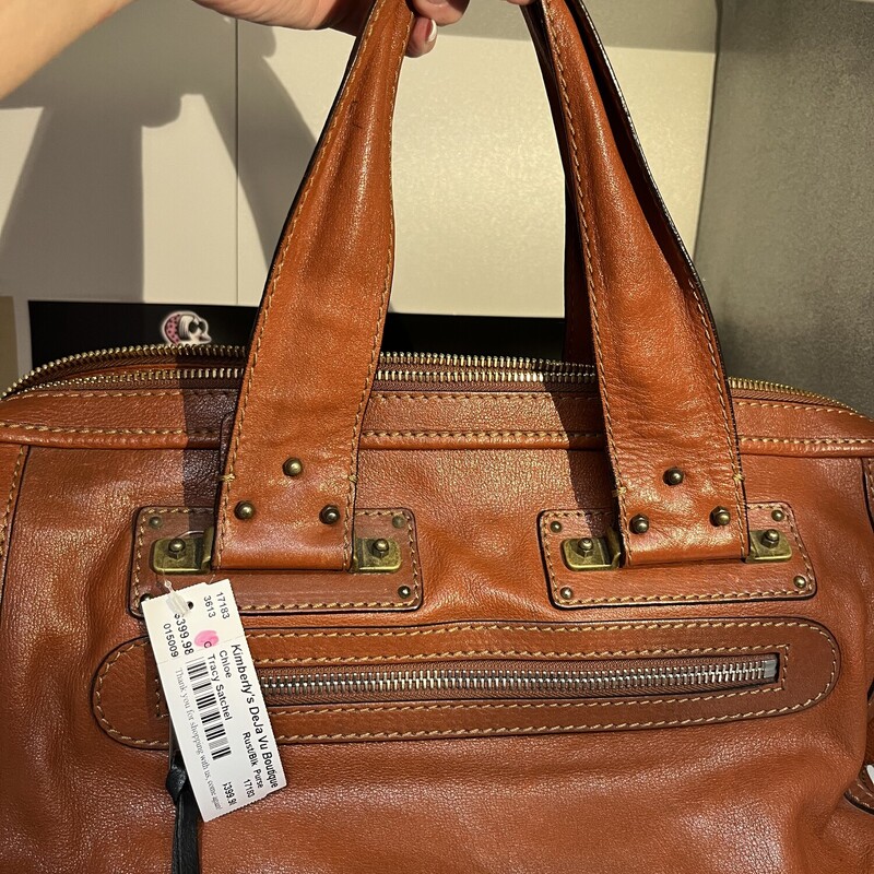 Tracy Satchel, Rust/Black,<br />
Size:<br />
Height 9.45 Inches<br />
Width 5.32 Inches<br />
Length 16.93 Inches<br />
One Studded grommet missing on back left side handle. See photos!