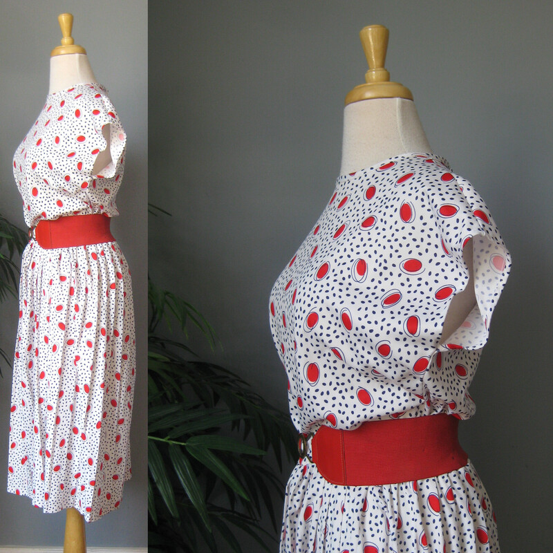 Cute little print dress from the 60s or 70s. It's white with red shapes and black lines.  The waist is elastic.
The skirt is pleated and full
I will send it with the red belt it's shown with even though
    a. it didn't come with it and
    b. the belt, while nice and snappy, is a bit stained.
Ulined.
It has a button and loop at the back of the neck, the elastic on the loop is stretched out.
No tags.
Flat measurements, please double where appropriate:

Armpit to Armpit: 20
Waist: 16 stretches easilyl to 19
Hips: free
Length: 44
Great vintage condition!

Thanks for looking.
#54095